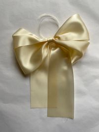 A smooth satin bow tied in pale butter yellow