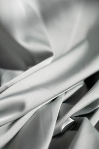 Smooth pale satin in soft flowing waves, photographed close